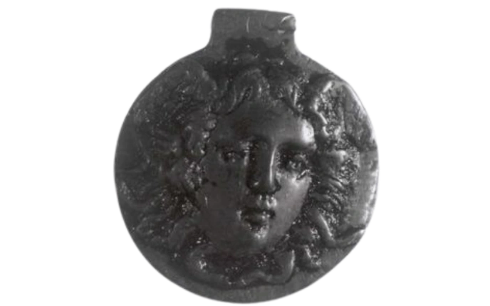 Small round black pendant with face carved into it