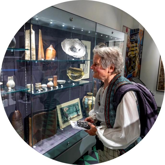 Person looking at objects displayed in glass cabinet