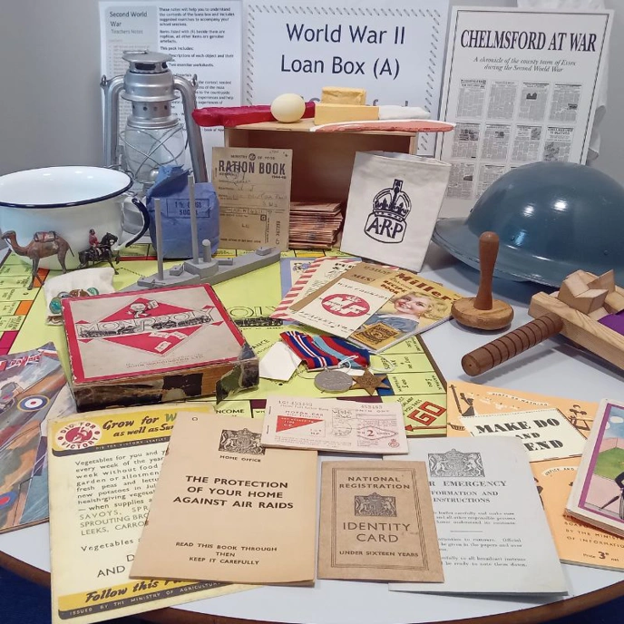 Collection of objects related to WW2, including ration books and tin helmet