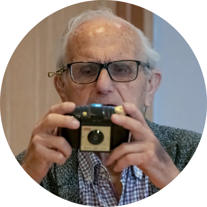 Older man looking at vintage camera